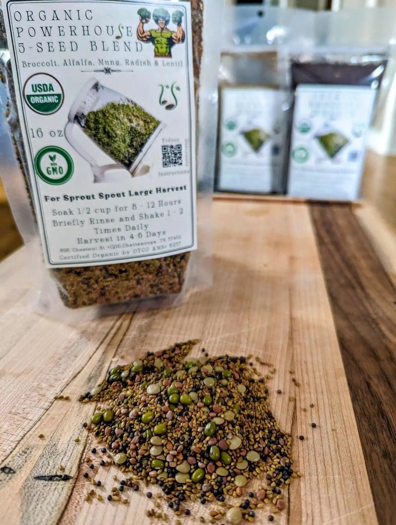 A pile of Organic Powerhouse 5-Seed Blend on a wooden board next to a 16 oz Sprout Spout seed pouch.
